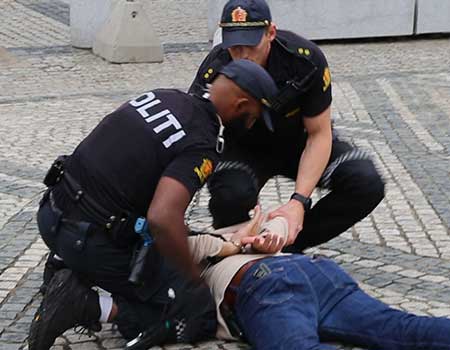 Police officers arresting suspect after weapon detection in Oslo